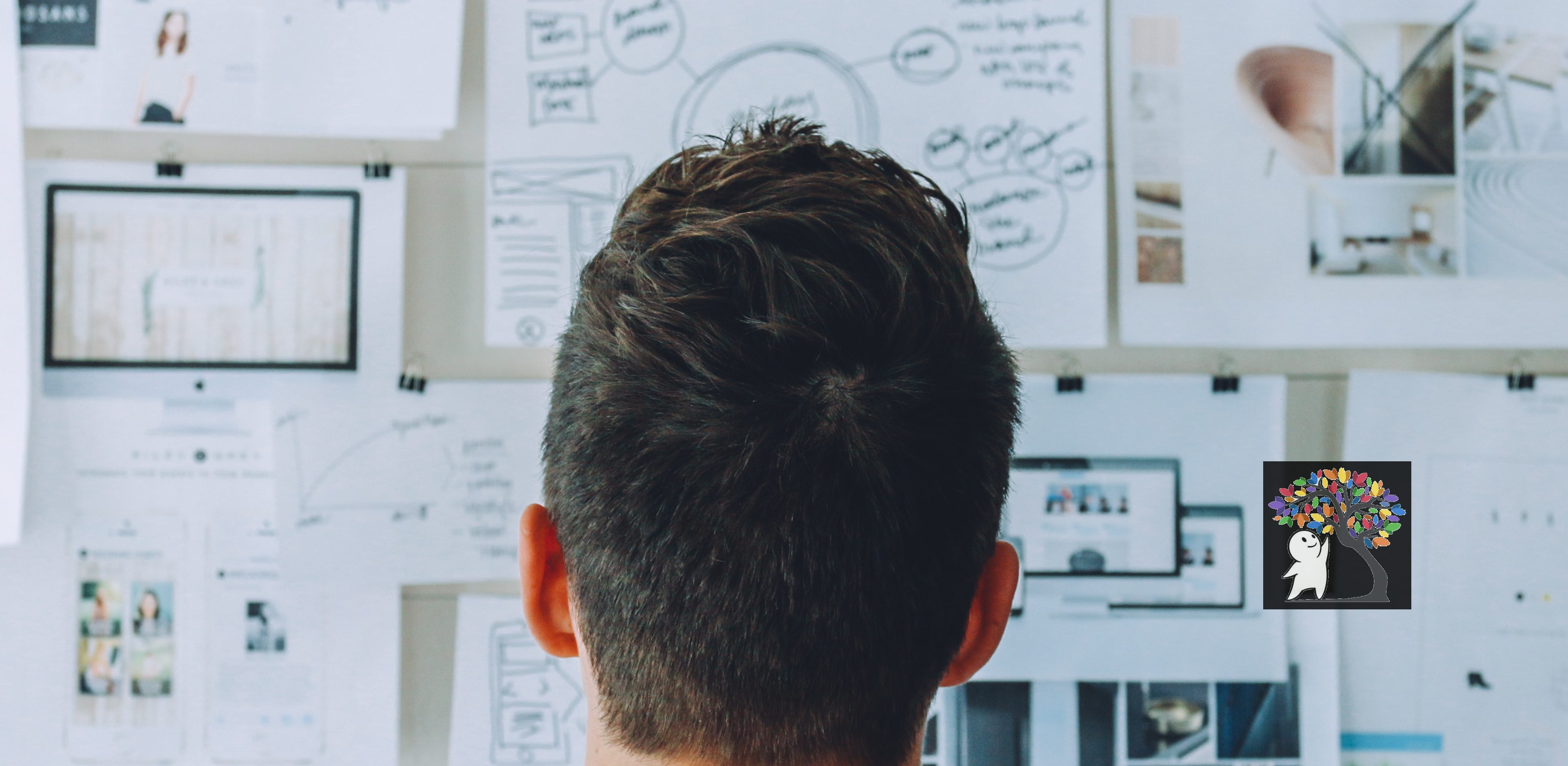 A man staring at a wall full of informative papers