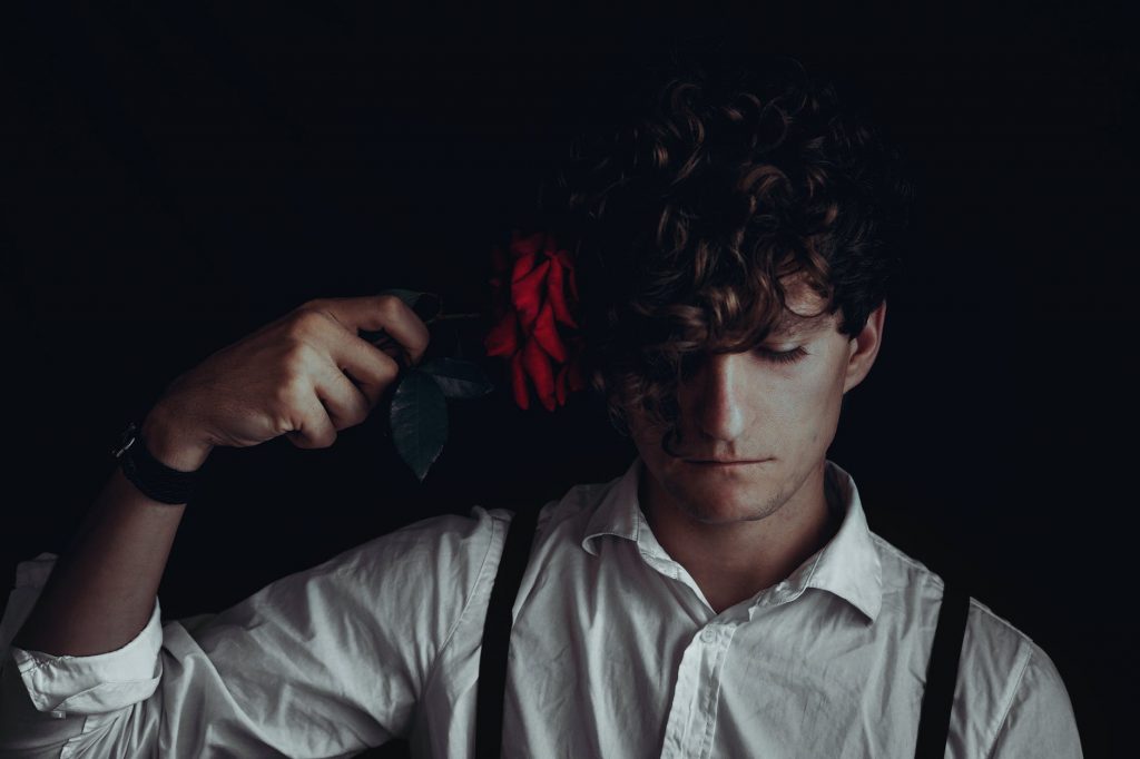 youngster putting rose flower to head in suicidal thoughts