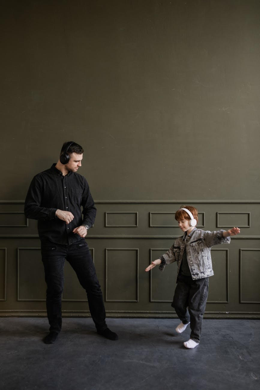 father and son dancing while listening to music