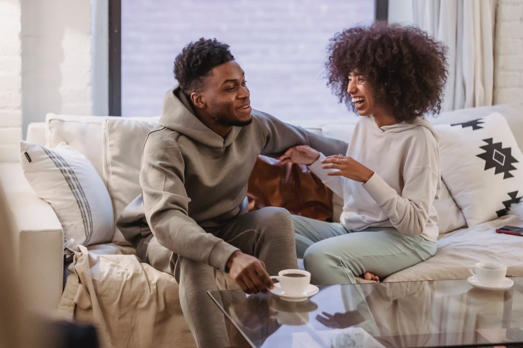 happy black couple sharing news and smiling at table