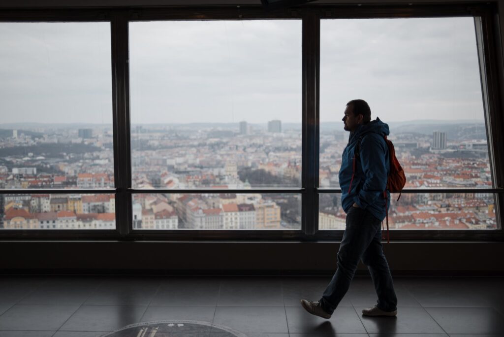 man walking along windows in modern building