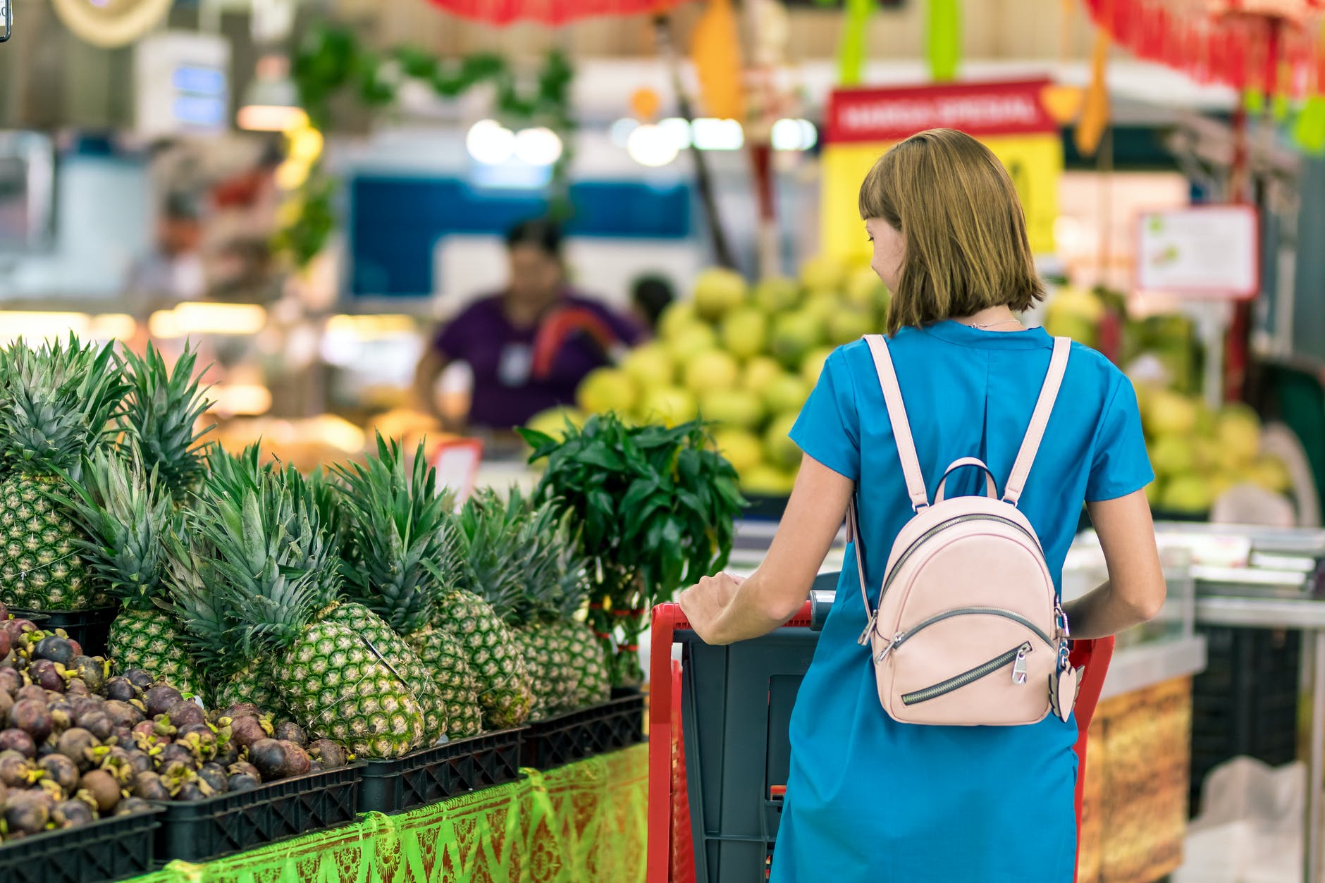 woman standing beside pineapple fruits