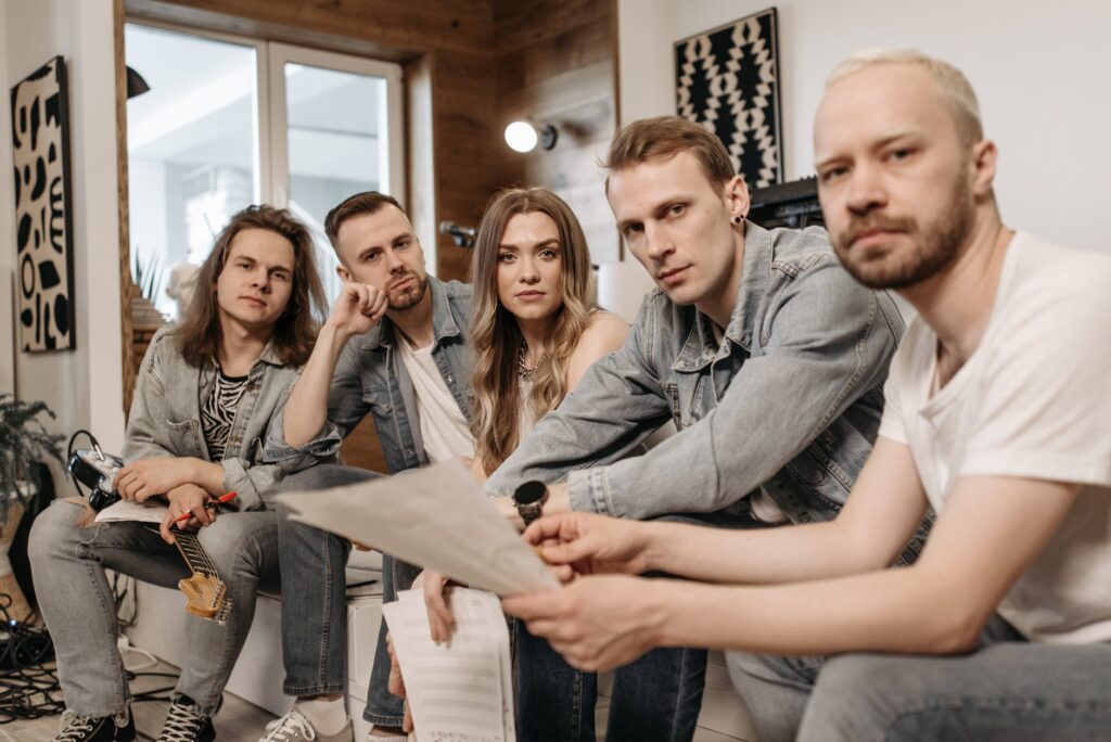 a group of men and a woman sitting on a bench