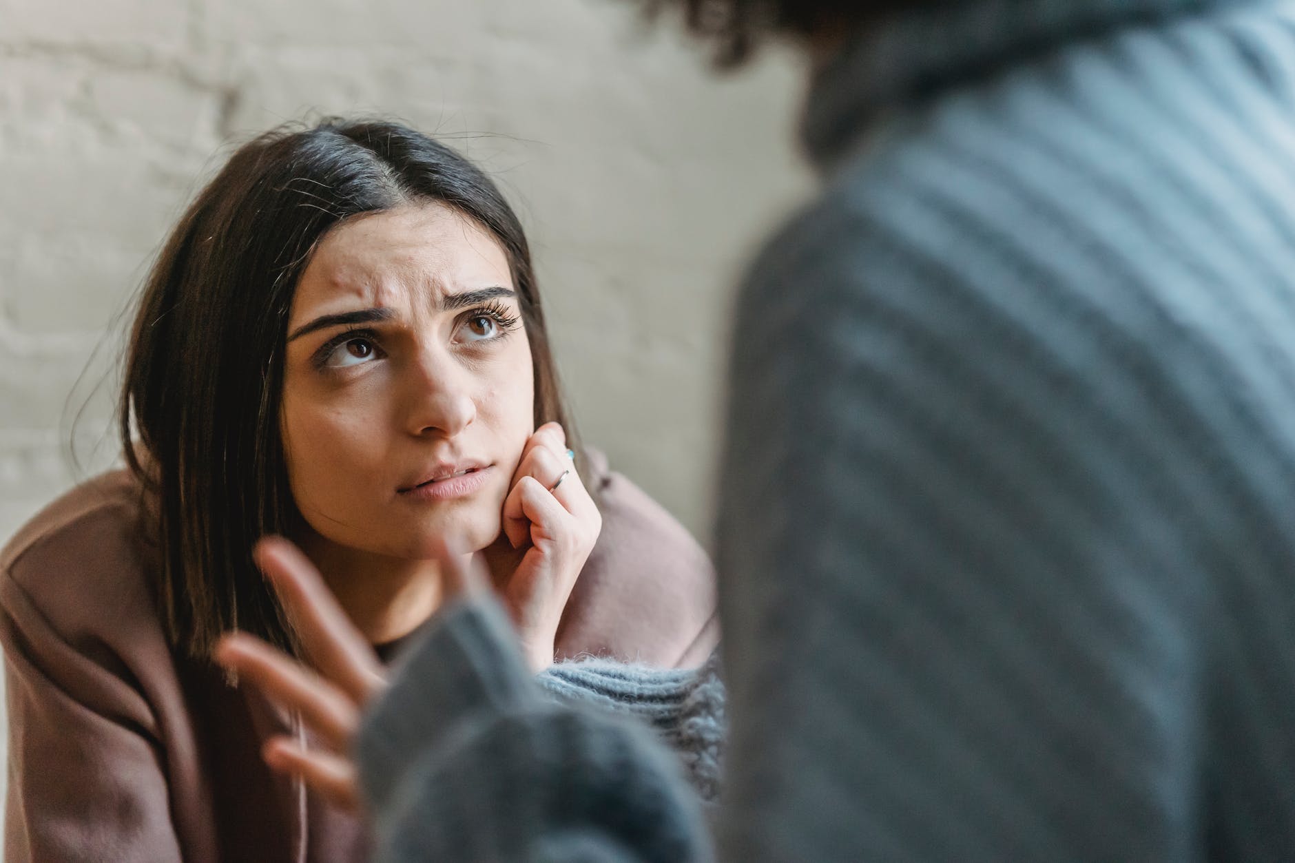 sad woman looking at anonymous woman during conflict