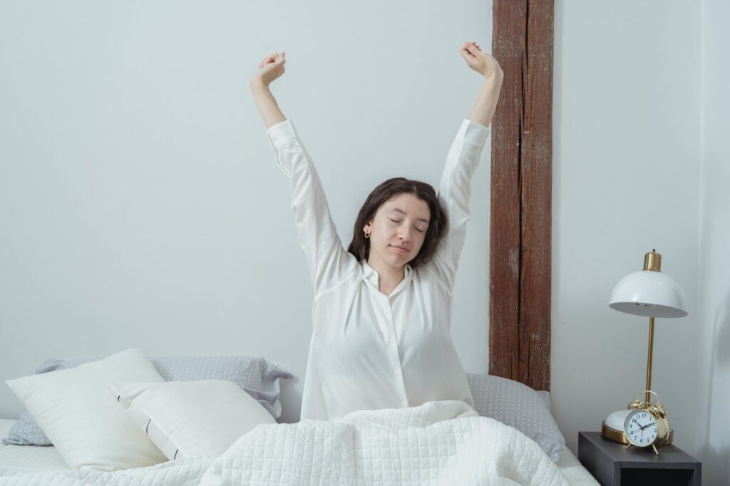 sleepy woman waking up on bed in morning