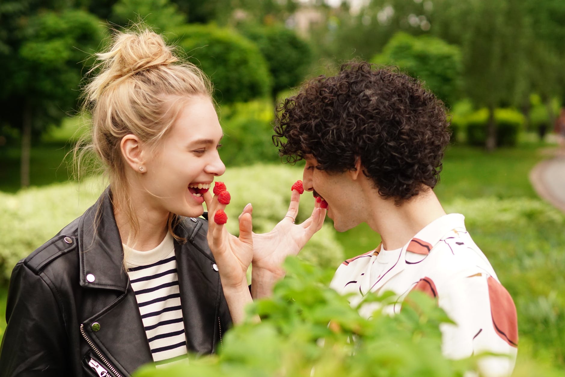 a playful couple eating raspberries